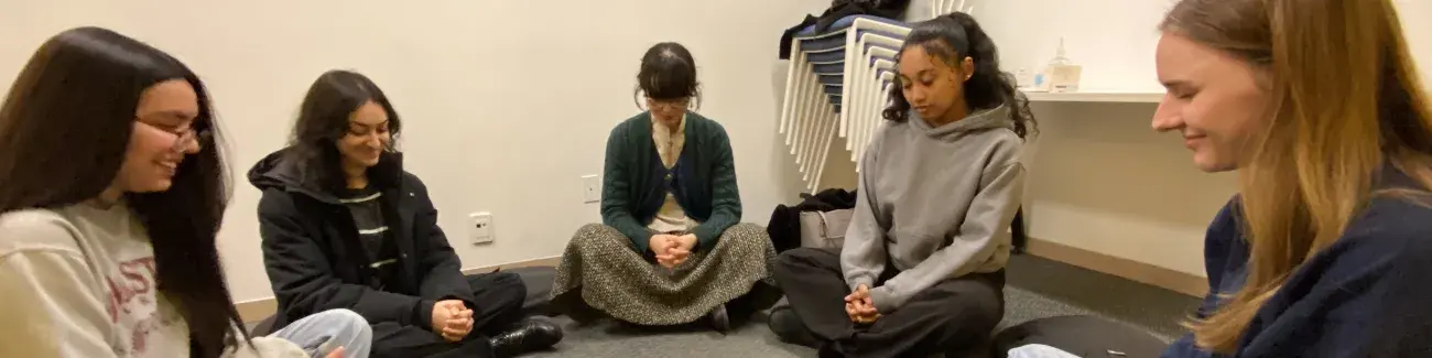 A group of students sitting in a circle and meditating